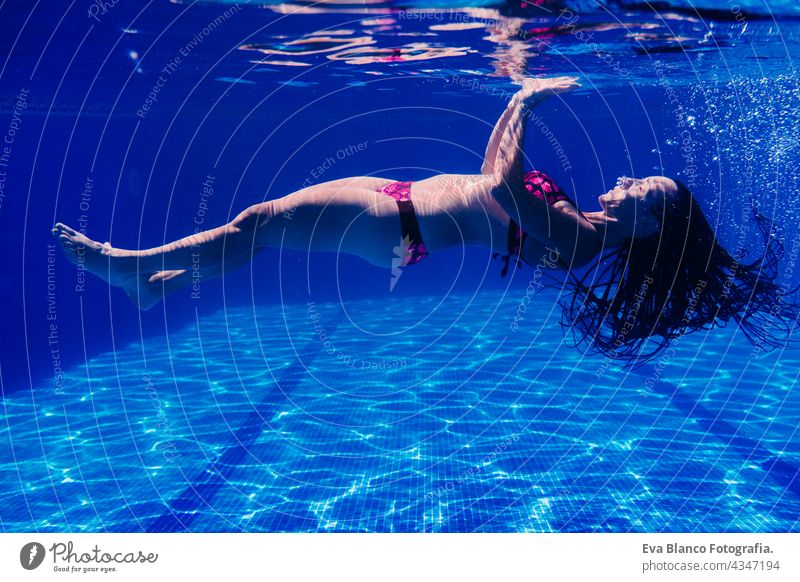 caucasian woman diving in swimming pool. underwater view. Summer time and vacation concept fun summer love blue water sunny day outdoors relax happy beautiful