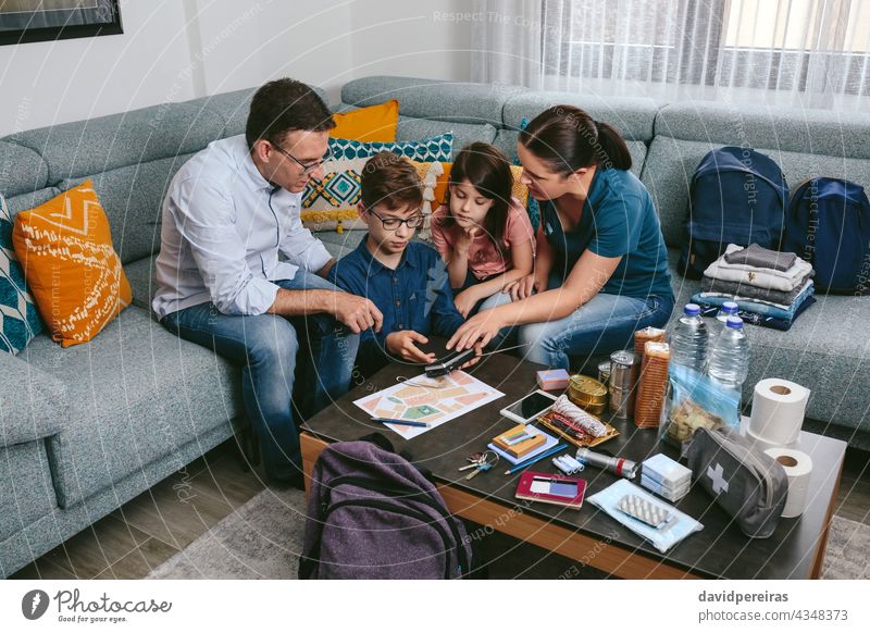 Mother explaining to her children how to use the radio in an emergency mother family prevention backpack bug out bag disaster evacuation safety necessities meet