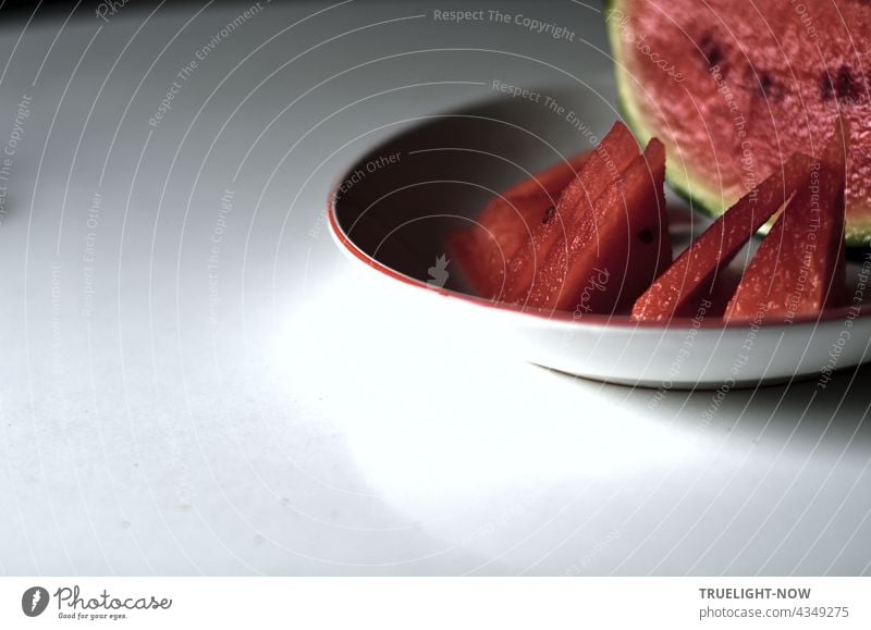 Early daylight - A melon, cut up - Red glows the fruit. Derby Water melon fruits Sliced Juicy Fresh fruit plate White Shallow depth of field Calm Table