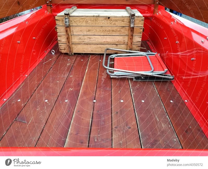 Loading area with wooden box and camping chair of a bright red American pick-up of the sixties at the classic car meeting in Wettenberg Krofdorf-Gleiberg near Gießen in Hesse