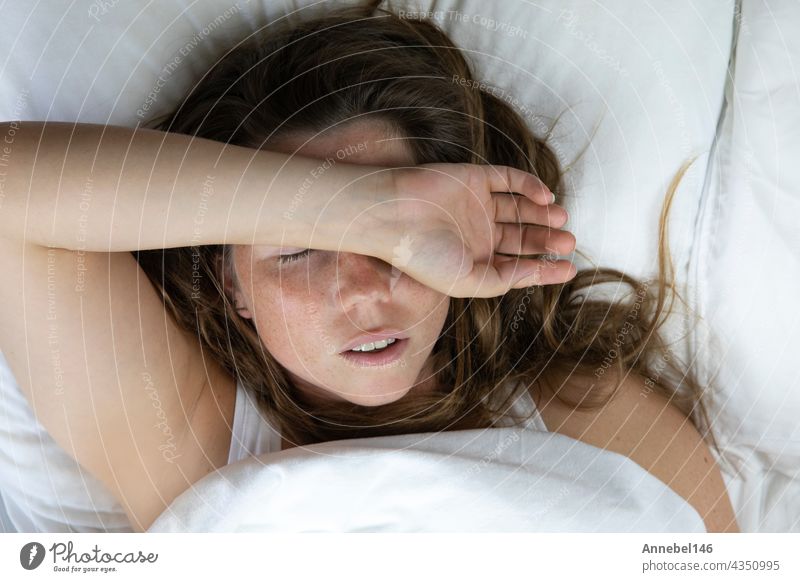 Young girl with freckles sleeping with white sheets top view, Portrait of the beautiful young woman sleeping in white bed in clean bedroom, lying down pillow