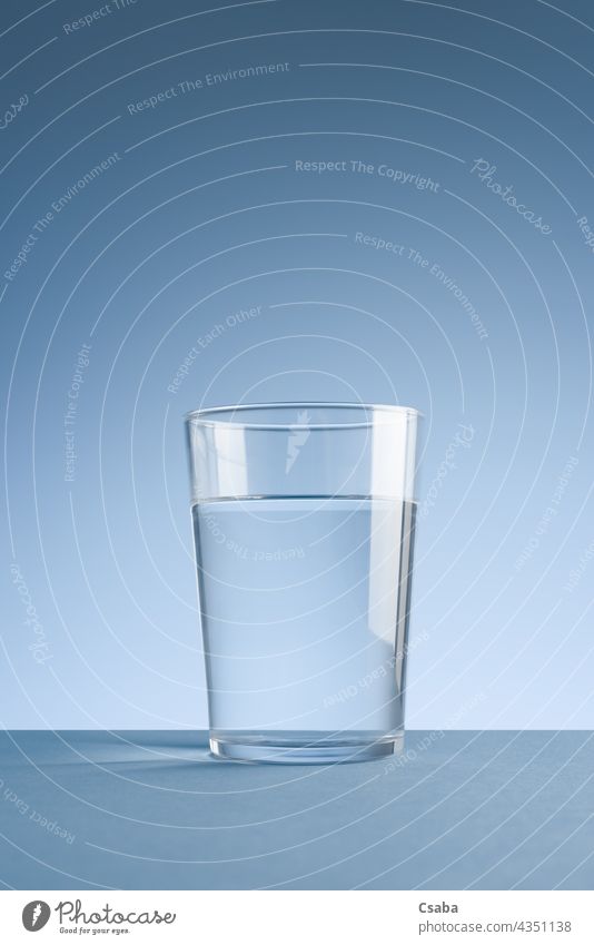 Minimalist photo of glass of clean drinking water on blue background Water Glass Clean Clear Drinking water Minimalistic Beverage Liquid Transparent Blue Purity