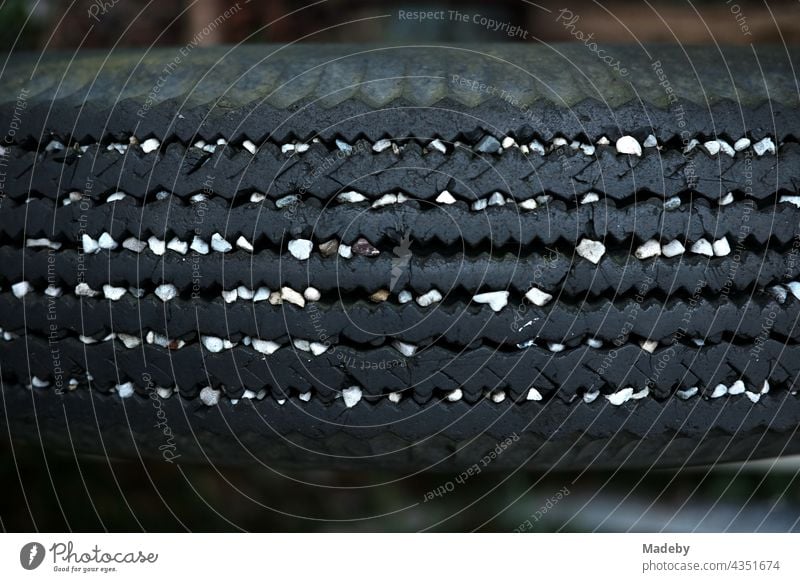 White pebbles in the tread of an old car tyre of a trailer for agriculture on a farm in Rudersau near Rottenbuch in the district of Weilheim-Schongau in Upper Bavaria