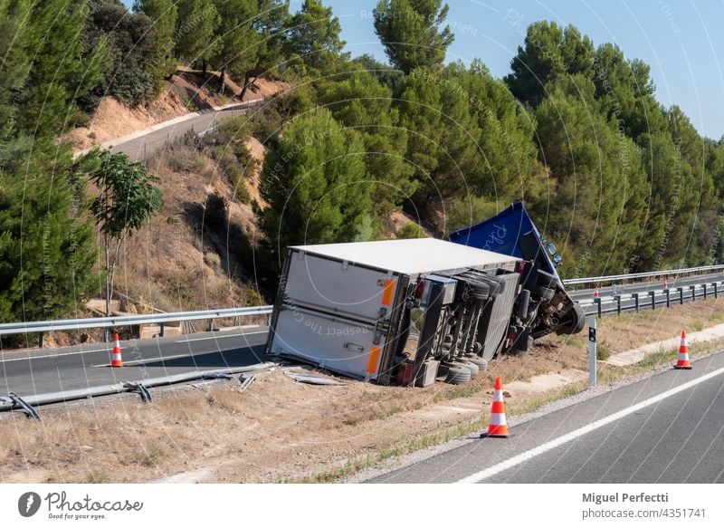 Truck with an accident refrigerated semi-trailer, overturned by the exit of the highway in the median of the highway. Camion Accidente Vuelco Frigorifico