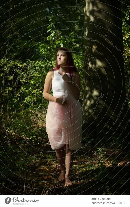 young woman standing barefoot in tulle skirt in forest Young woman Fairy Elf wood nymph Forest Stand Barefoot Skirt Sunlight Mystic Nature Day Upward enchanted