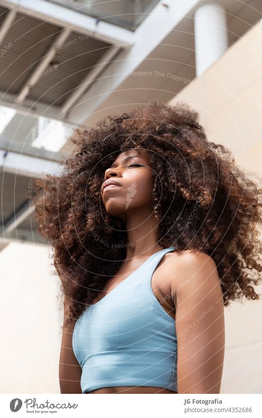 Young black woman closed eyes with curly hair style look afro closeup latin curls hispanic young hairstyle beauty portrait girl african glamorous blue tropical