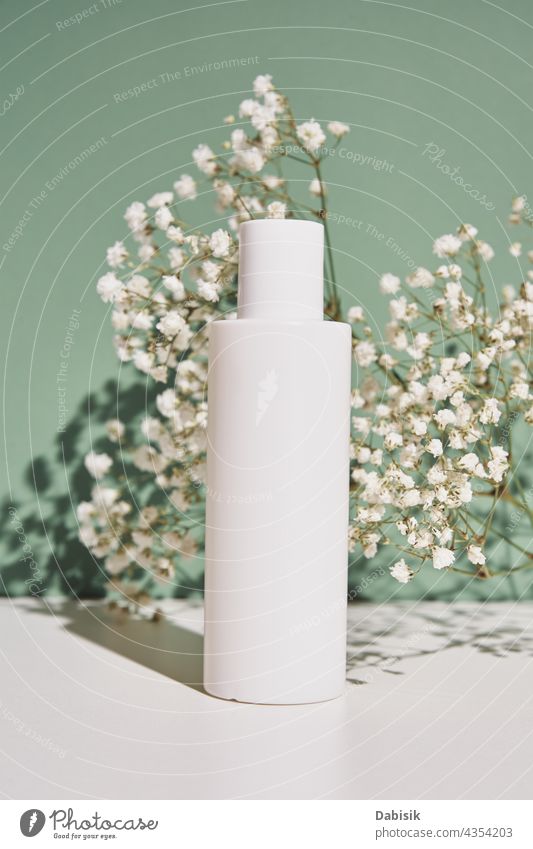 Natural cosmetic cream bottle on green background with plant product beauty package mock up label clean hygienic lotion container design white medical shadow