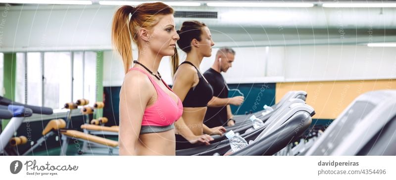 People training over treadmills on fitness center panorama people group woman machine copy space jogging warming up cardio running class sport banner exercise