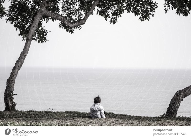 Baby sitting in front of the sea beach girl sun people happy water back vacation ocean cute little baby toddler young summer portrait beautiful caucasian white