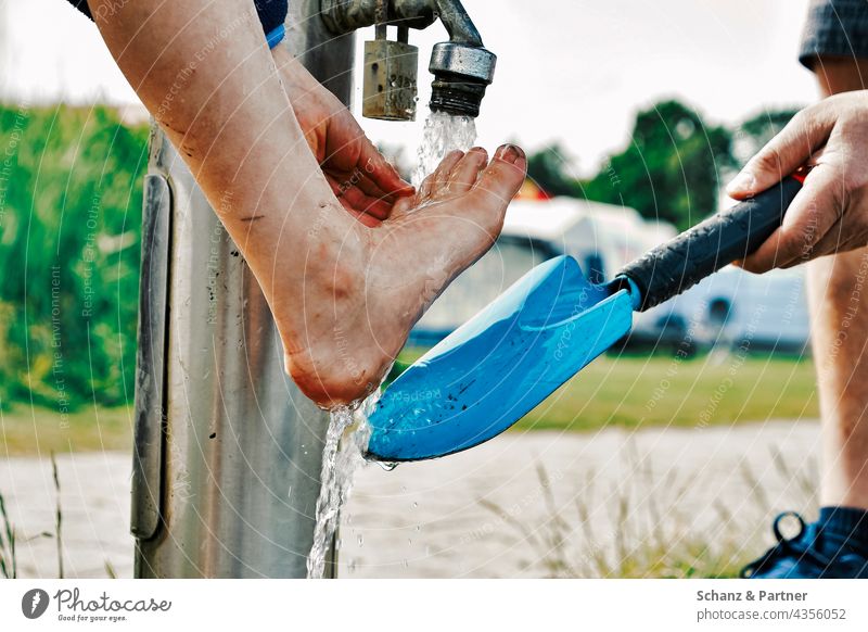 Washing feet after a mudflat hike Feet Mud flats mudflat hiking tour Shovel Blue Water Tap Ocean Relaxation Sand North Sea family vacation Cleaning Beach coast