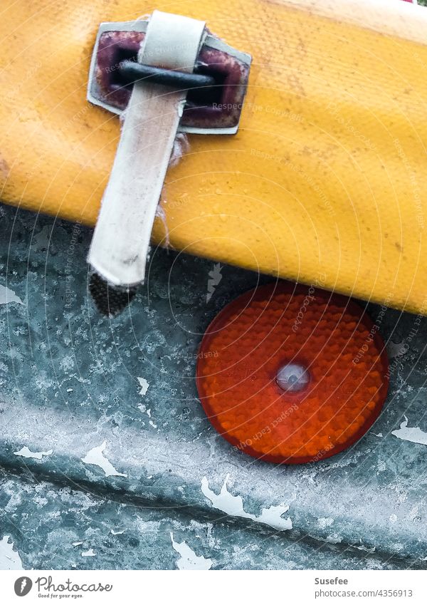 Detail of a vehicle detail Close-up Vehicle Parts of Vehicle Cat eyes Metal Orange Yellow Trailer Covers (Construction) Buckle