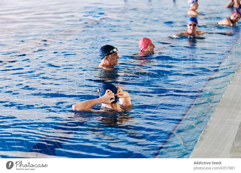 Company of people in swimming pool during water aerobics training company exercise group class aqua activity healthy practice workout body wellness vitality