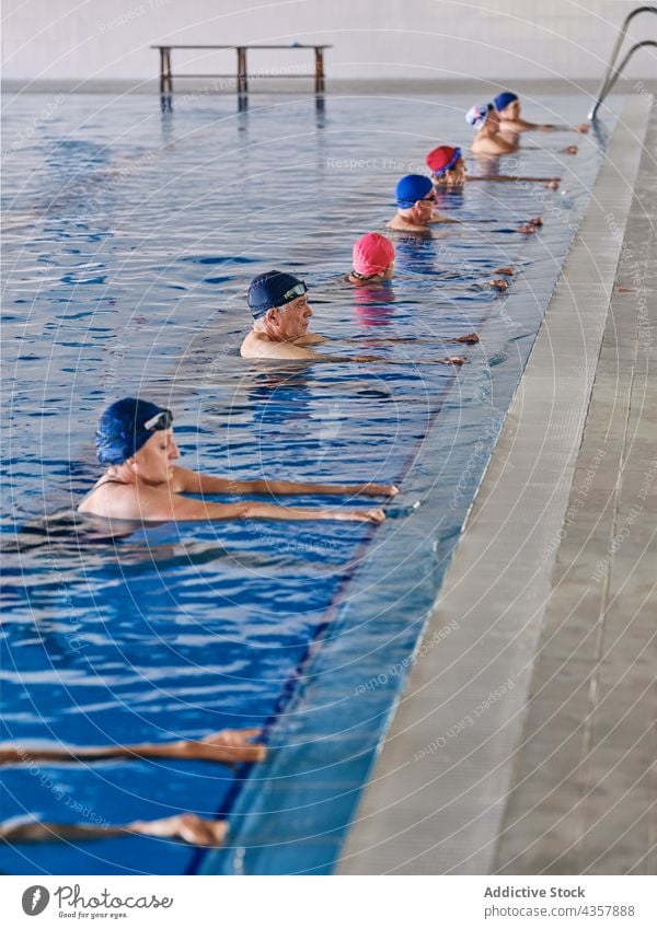 Company of people in swimming pool during water aerobics training company exercise group class aqua activity healthy practice workout body wellness vitality