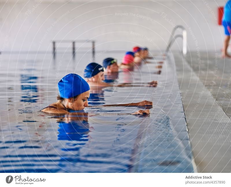 Company of people in swimming pool during water aerobics training company exercise group class aqua activity healthy practice workout body wellness vitality