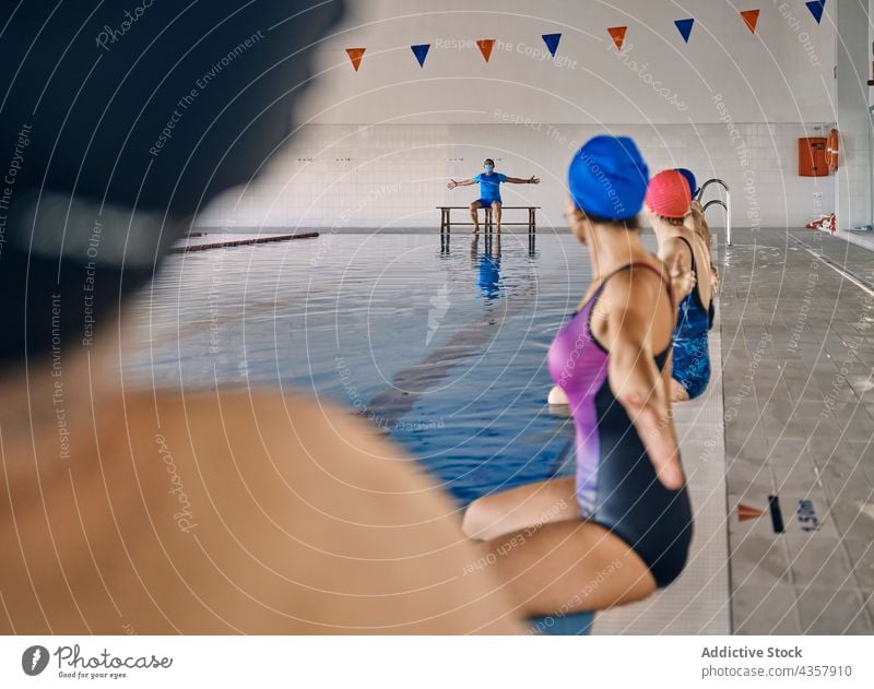 Company of people doing exercise during water aerobics company instructor trainer pool poolside training activity healthy practice sit workout body wellness