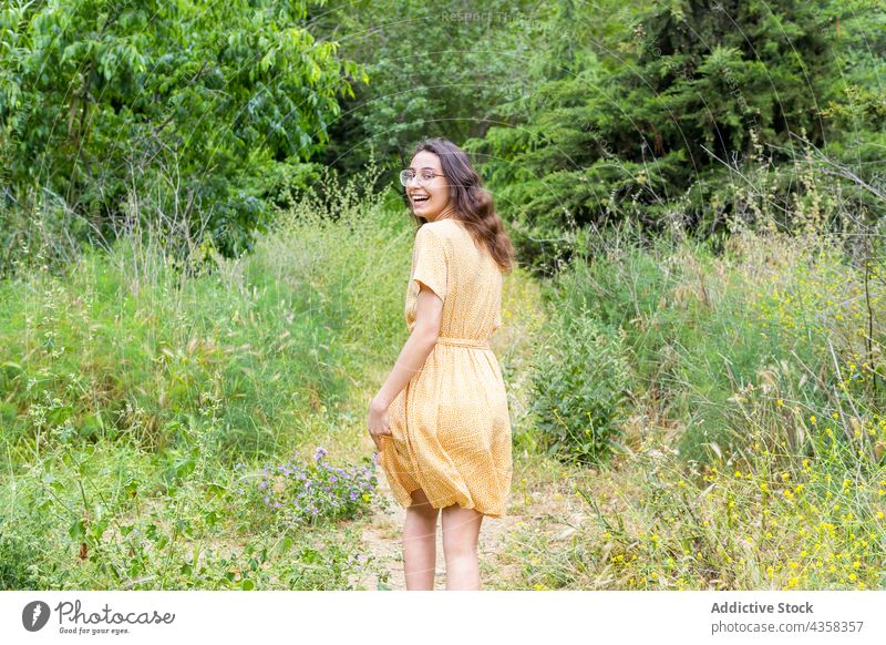 Carefree woman walking in summer park dress smile cheerful carefree enjoy stroll female delight nature style positive charming happy optimist glad weekend green