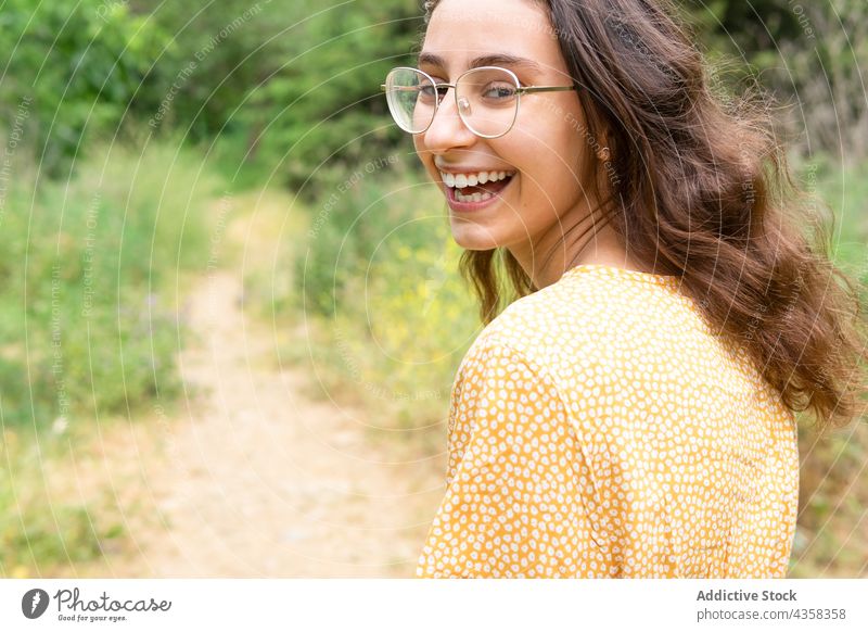 Carefree woman walking in summer park dress smile cheerful carefree enjoy stroll female delight nature style positive charming happy optimist glad weekend green