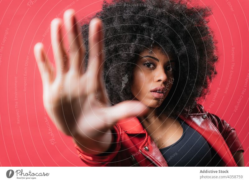 Scared black woman showing stop sign on red background gesture scare protect prohibit no expressive reject female ethnic african american negative aggressive