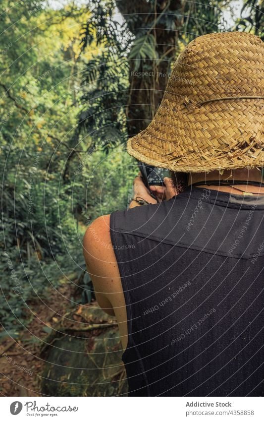 Unrecognizable traveling man taking picture on photo camera in forest photographer take photo summer vacation memory moment photography male nature traveler