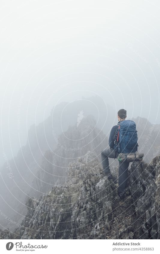 Unrecognizable man standing in mountains on foggy day hiker highland trekking adventure mist dramatic traveler male wales united kingdom uk great britain