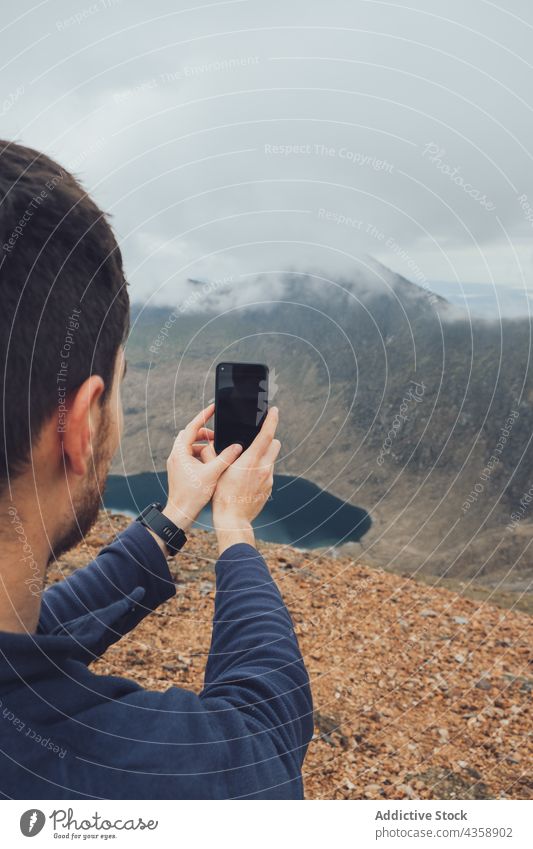 Traveling man taking photo of mountains on foggy day take photo smartphone traveler hiker trekking highland mist male wales united kingdom uk great britain