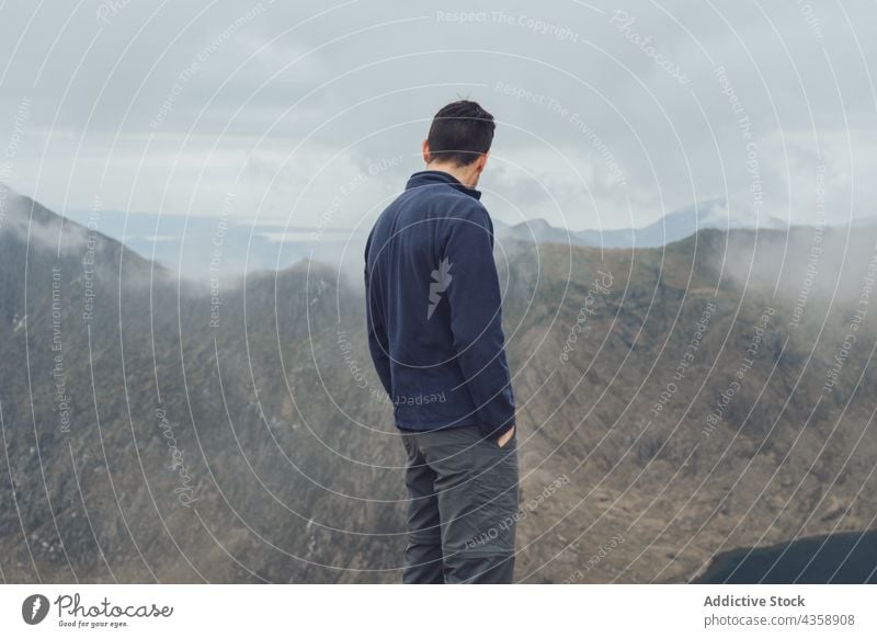 Unrecognizable male hiker standing in mountains traveler admire highland viewpoint man trekking observe wales united kingdom uk great britain wanderlust lake