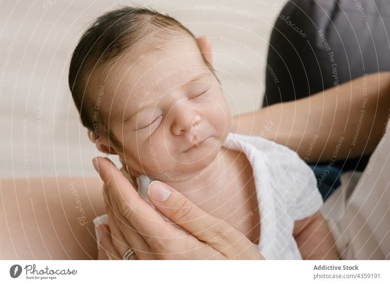 Anonymous delicate mother sitting on floor with newborn at home sleep baby together love infant innocent female woman cute adorable care parent little tender