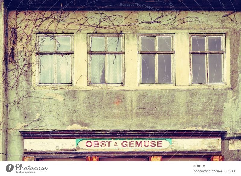 House facade with four windows and a sign " Fruit and vegetables " / Crosseffekt / Lost Place / Property / house facade Facade Window Junk shop