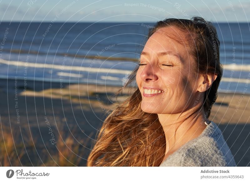 Carefree woman on seashore in summer beach sunset carefree enjoy tranquil harmony sundown female relax coast calm serene eyes closed seaside idyllic twilight