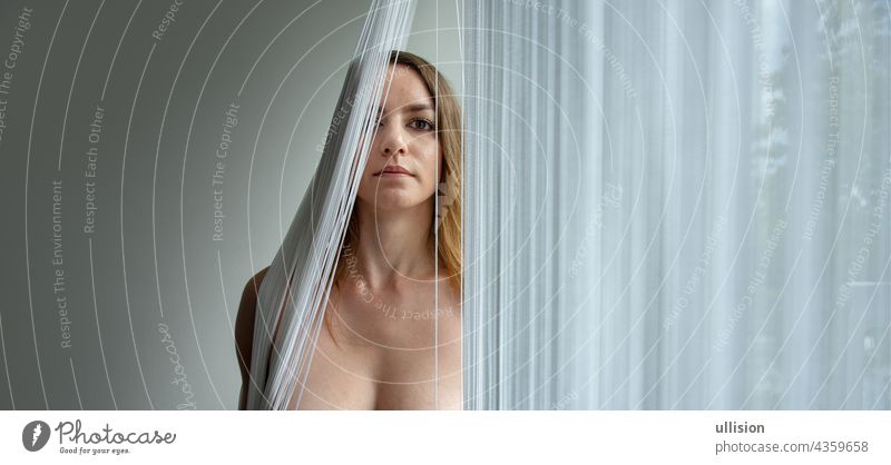 colored portrait of a young attractive woman behind a string curtain with copy space, place for text. thread blind sexy beautiful fall mask mouth chin nude