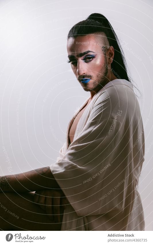 Stylish transgender woman posing at studio transvestite lgbt male glamorous bearded fashion transsexual make-up lgbtq looking at camera person feminine portrait