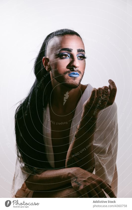 Stylish transgender woman posing at studio transvestite lgbt male glamorous bearded fashion transsexual make-up lgbtq looking away person feminine portrait