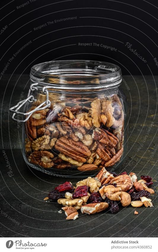 Glass jar with nuts and dried fruits food seed almond snack cranberry granola raisin homemade vegetarian glass healthy dessert diet organic sweet grain