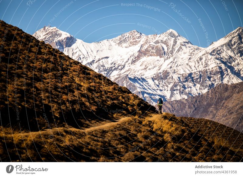 Unrecognizable traveler walking along trail in mountainous terrain trekking adventure highland backpacker wanderlust explore himalayas nepal explorer hike hiker