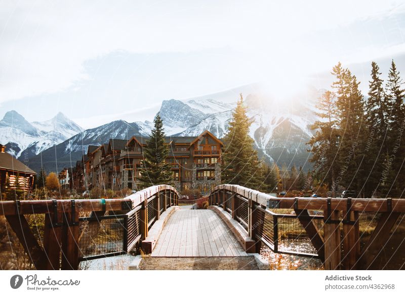 Bridge and houses on riverside in mountainous terrain bridge autumn landscape footbridge pathway nature environment walkway journey highland viewpoint wooden