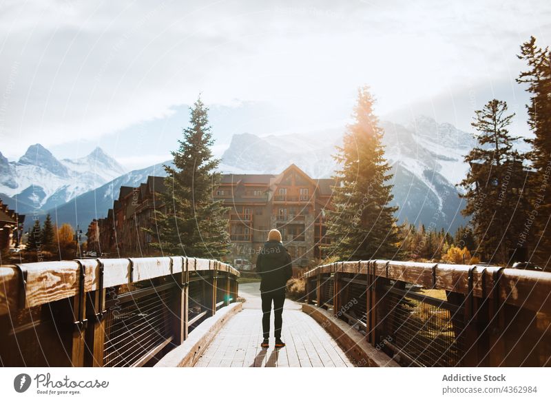 Man admiring mountain landscape from wooden footbridge man traveler nature autumn journey explore environment male tourism banff national park canada canmore