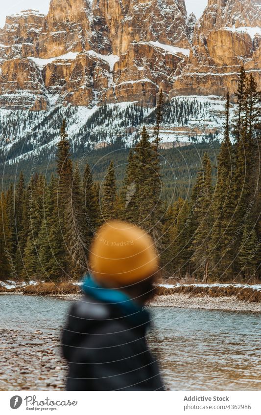 Unrecognizable tourist admiring mountain and forest admire shore river nature tree snow coniferous castle mountain banff national park alberta canada traveler