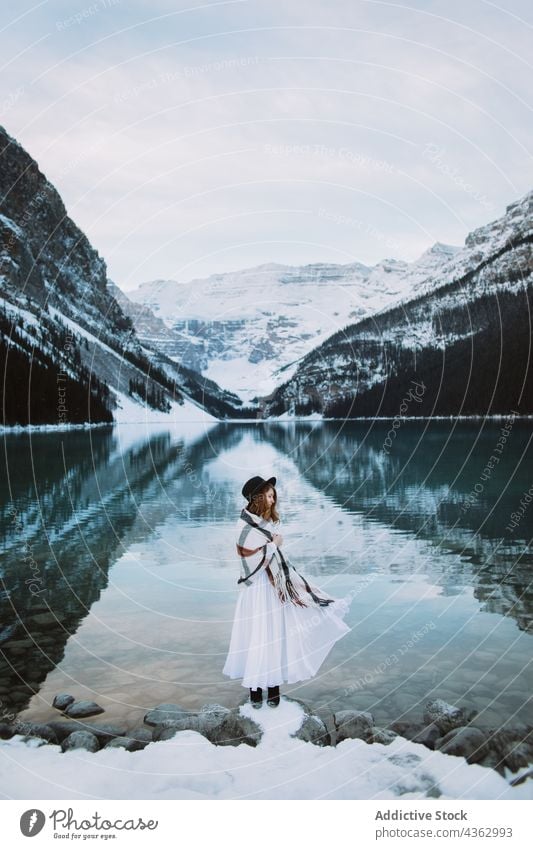 Woman standing towards lake in winter woman shore mountain nature snow cold travel lake louise banff national park alberta canada water clean ridge countryside