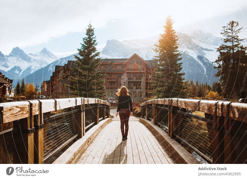 Woman admiring mountain landscape from wooden footbridge woman traveler nature autumn journey explore environment female tourism banff national park canada