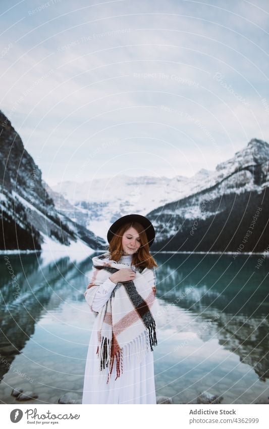 Woman standing near lake in winter woman shore mountain nature snow cold travel lake louise banff national park alberta canada water clean ridge countryside