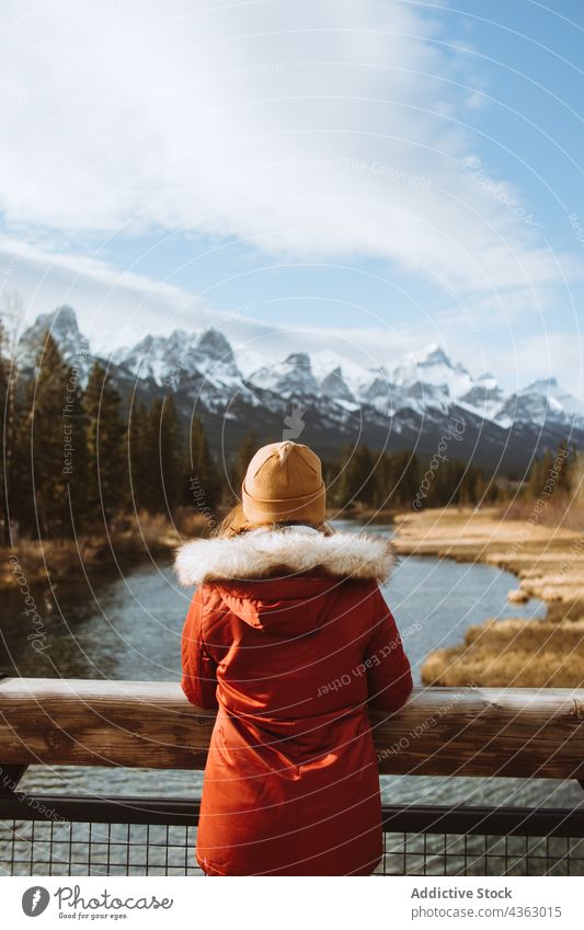 Woman in warm clothes admiring mountains landscape woman traveler nature alone river autumn environment explore journey wanderlust female tourism