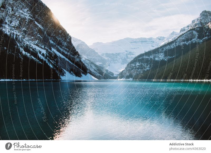 Calm lake reflecting snowy mountains winter reflection shore calm clean sky cloudy lake louise banff national park alberta canada water ridge nature range