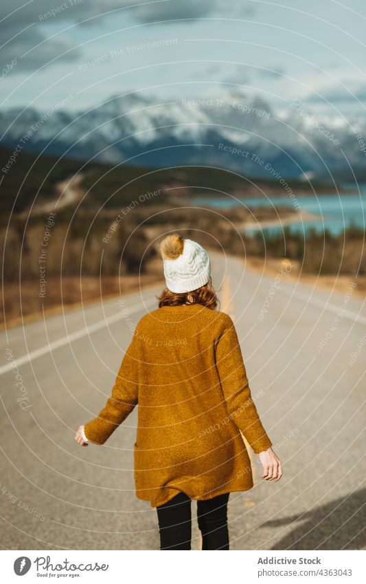 Anonymous woman walking on asphalt road in countryside traveler trip weekend mountain nature david thompson highway banff national park alberta canada tourism