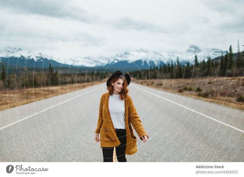 Woman walking on asphalt road in countryside woman traveler trip casual weekend mountain nature david thompson highway banff national park alberta canada