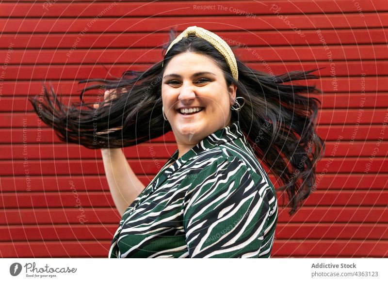 Happy stylish woman with flying hair headband shaking hair happy style stripe brunette cheerful having fun fashion long hair young female accessory trendy curvy