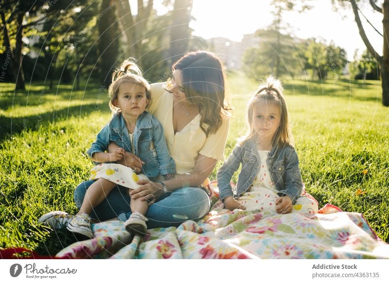 Mother with little daughters resting in park mother kid together summer sibling love happy similar cute cuddle child mom relationship children sister alike