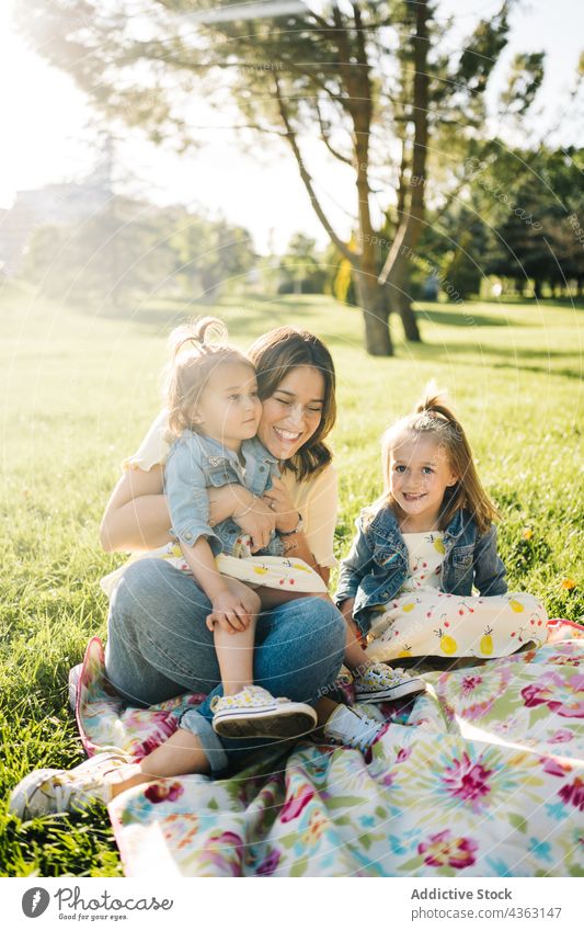 Mother with little daughters resting in park mother kid together summer sibling love happy similar cute cuddle child mom relationship children sister alike