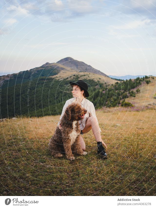 Woman with fluffy dog on meadow woman labradoodle friend animal pet owner female canine mountain together loyal breed nature companion countryside best friend