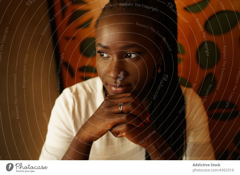 Thoughtful black woman chilling in cafe enjoy serene thoughtful braid hairstyle weekend charming female ethnic african american lean on hand peaceful calm