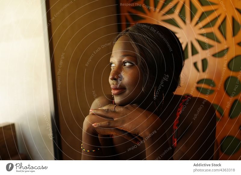 Thoughtful black woman chilling in cafe enjoy serene thoughtful braid hairstyle weekend charming female ethnic african american lean on hand peaceful calm